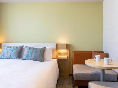 a hotel room with a bed and a table at Tokyu Stay Hakata in Fukuoka