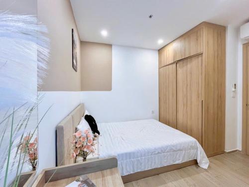 a bedroom with a bed and a wooden cabinet at The Sóng Vũng Tàu- SAO VIỆT Căn Hộ Nghỉ Dưỡng 5 Sao in Vung Tau