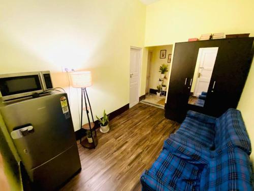 sala de estar con nevera y sofá en Mini Studio close to Quest Mall, en Calcuta