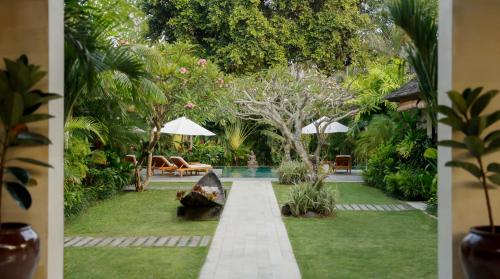 Blick auf einen Garten mit Pool in der Unterkunft Villa Nelayan by Nakula in Canggu