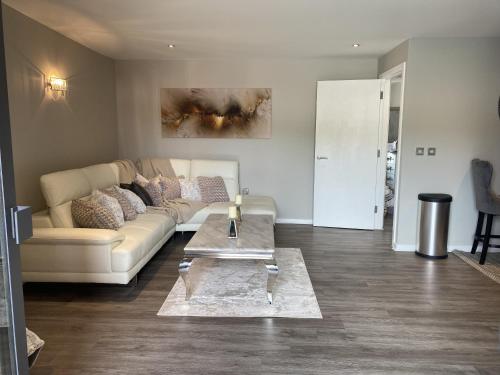 a living room with a couch and a table at Hideaway Bay in Swansea