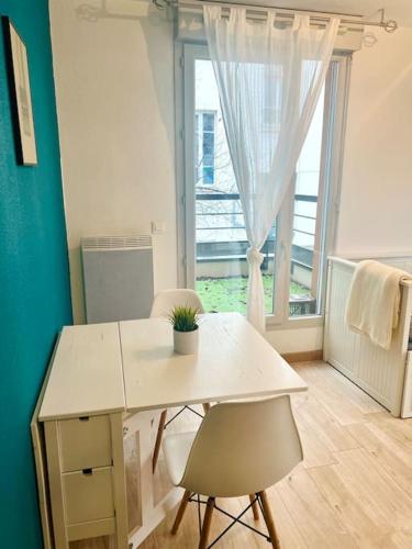 une pièce avec une table et deux chaises et une fenêtre dans l'établissement Studio Berlioz - charme, confort, terrasse privée, à Villeurbanne