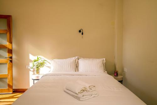 a bed with white sheets and towels on it at Colombo Villa Collection in Colombo