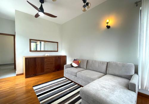 a living room with a couch and a tv at Baywatch - Pieds dans l'eau avec piscine in Baie du Tombeau