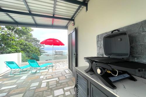 a living room with a tv and a patio at Baywatch - Pieds dans l'eau avec piscine in Baie du Tombeau