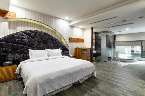 a bedroom with a large bed and a bathroom at OHYA Chain Boutique Motel-Xinying in Xinying