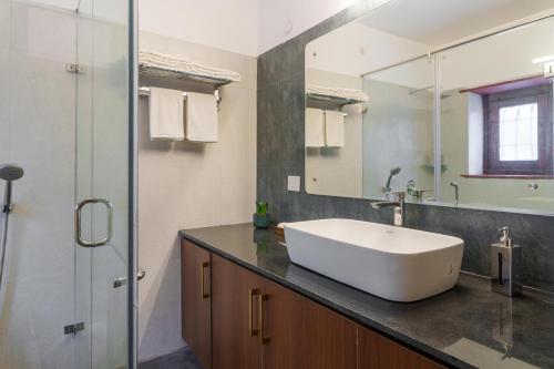 a bathroom with a white sink and a mirror at amã Stays & Trails Lotus Dhauj , Haryana in Faridabad