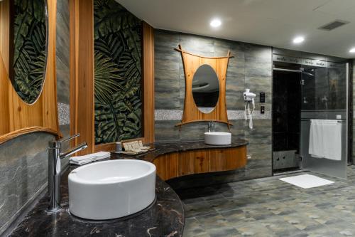 a bathroom with a sink and a large mirror at OHYA Chain Boutique Motel-Xinying in Xinying