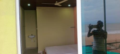 a bedroom with a view of the beach and a statue of a person at Aisiri comforts beach stay and cafe in Gokarn