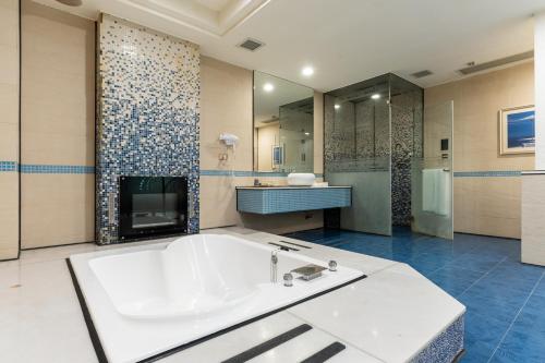 a large bathroom with a tub and a sink at OHYA Chain Boutique Motel-Xinying in Xinying