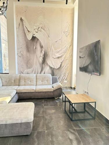 a living room with a couch and a painting on the wall at וילה גריי in El ‘Affūle