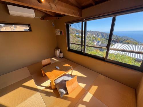a room with a table and a large window at ルネ熱海伊豆山villa134 in Atami