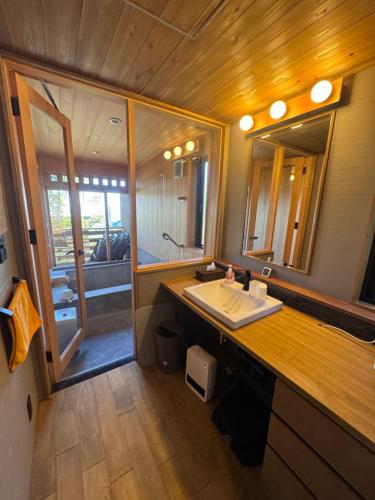 a bathroom with a sink and a large mirror at ルネ熱海伊豆山villa134 in Atami