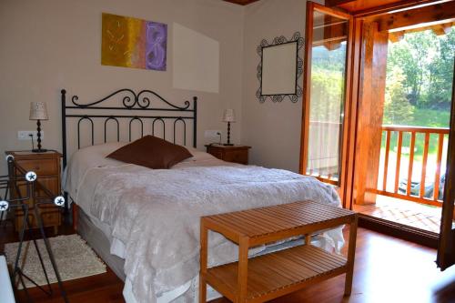 une chambre avec un grand lit et un balcon dans l'établissement Apartamento con piscina en Osseja, à Osséja