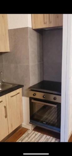 Il comprend une petite cuisine équipée d'un four avec plaques de cuisson noires. dans l'établissement Apartamento en les Deux Alpes, à Les Deux Alpes