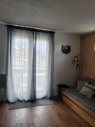 - une chambre avec une grande fenêtre et un lit dans l'établissement Apartamento en les Deux Alpes, à Les Deux Alpes