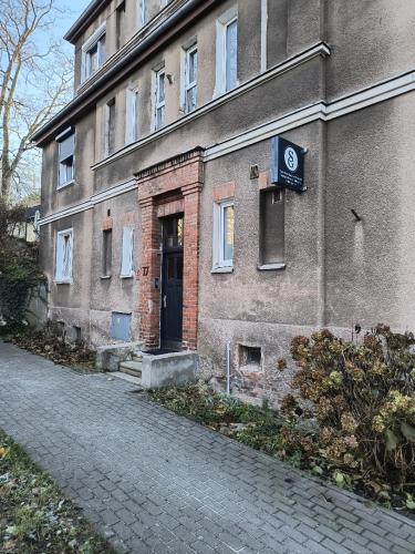 a brick building with a door and a sign on it at FLATMORE Apartament Akacjowa 17m1B in Zielona Góra