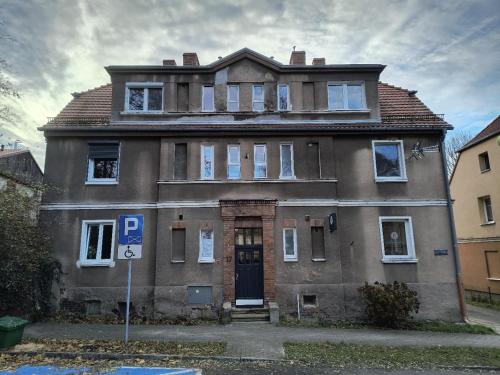 an old house with a parking sign in front of it at FLATMORE Apartament Akacjowa 17m1B in Zielona Góra
