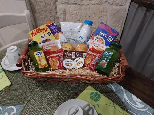 een mand gevuld met eten en drinken op een tafel bij BELOVED luxury room in Corato