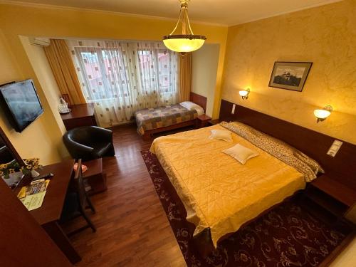 a hotel room with a bed and a chair at Casa Maria Arges in Piteşti