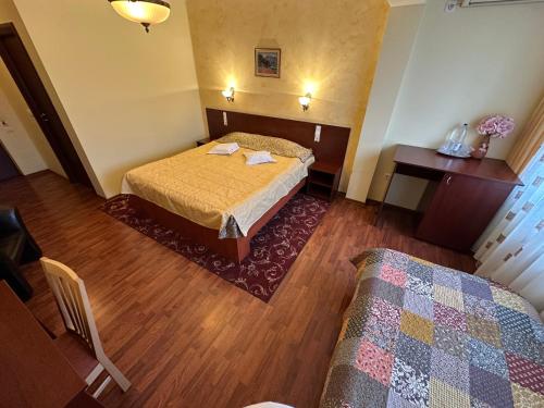 a hotel room with a bed and a table at Casa Maria Arges in Piteşti