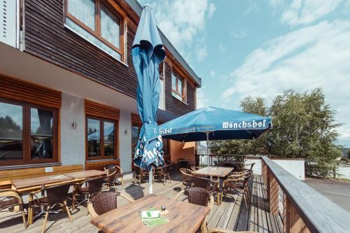 a patio with tables and chairs and an umbrella at Das Arni´s in Mehlmeisel