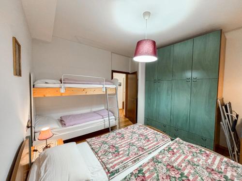a bedroom with two bunk beds and a red lamp at Appartamento Al Ruscello in Canazei