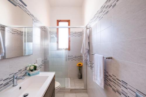 a white bathroom with a sink and a toilet at Villetta a San Foca in San Foca