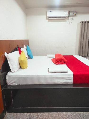 a bed with colorful pillows on it in a room at Hotel New Maruthi Inn, LB Nagar in Hyderabad