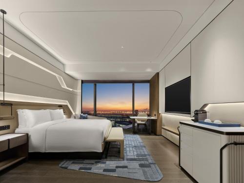 a hotel room with a bed and a television at Hilton Shanghai Hongqiao International Airport in Shanghai