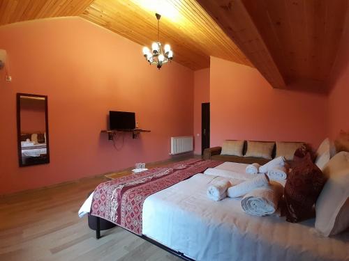 a bedroom with a large bed and a television at Château Fort de Manavi, Boutique Hotel in Manavi