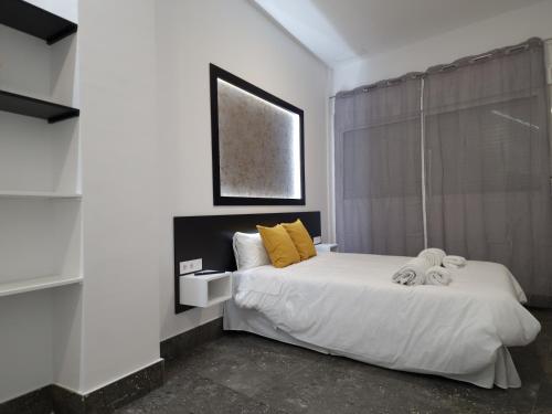 a bedroom with a bed with yellow pillows and a window at CARMELO APARTAMENTo in San Jose de la Rinconada