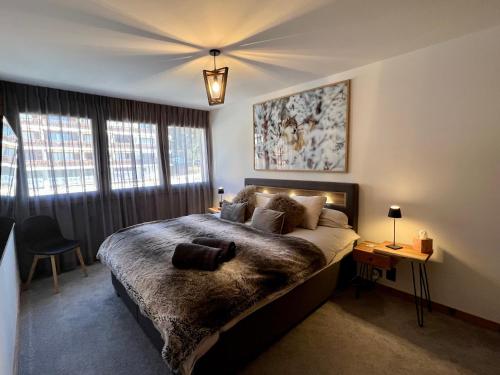 a bedroom with a large bed with a ceiling at Résidence Robin des Bois, Crans-Montana, luxueux appartement avec vue imprenable in Crans-Montana