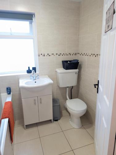 a bathroom with a toilet and a sink at Ivy Townhouse Derry in Derry Londonderry