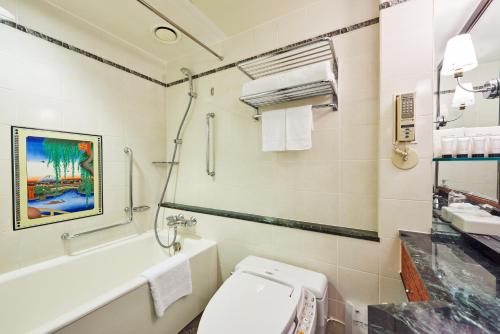 a bathroom with a toilet and a sink and a tub at Hotel New Otani Tokyo Garden Tower in Tokyo