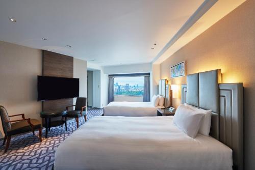 a hotel room with two beds and a flat screen tv at Hotel New Otani Tokyo Garden Tower in Tokyo