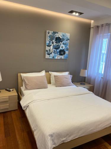 a bedroom with a large bed with white sheets and pillows at Lorena Suite with private pool in Dubrovnik