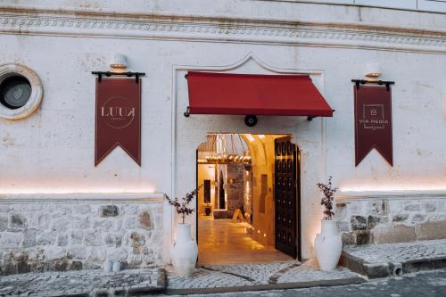 a doorway to a building with a red awning at Via Regia Cappadocia Hotel in Uchisar