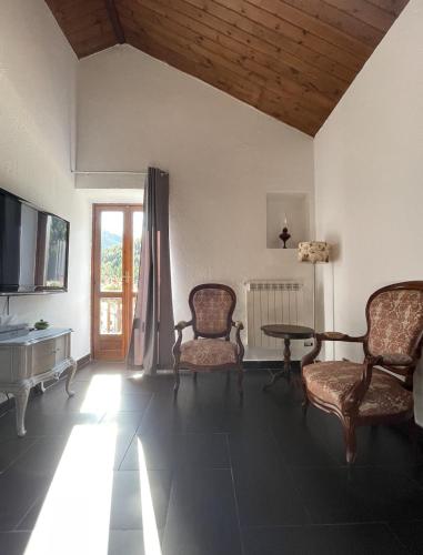 a living room with two chairs and a table and a television at Hotel Ristorante Il Principe in Claviere