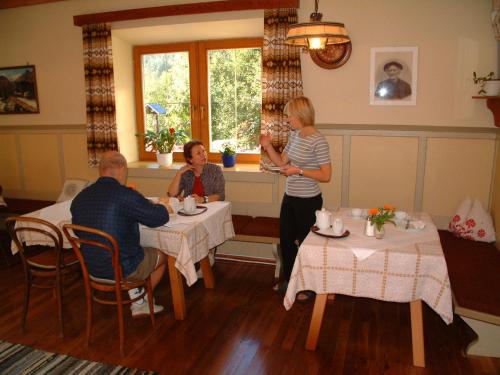 a group of people sitting at tables in a restaurant at Gästehaus Post in Prägraten am Großvenediger