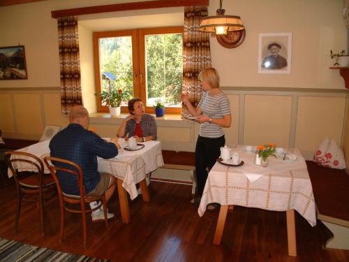grupa ludzi siedząca przy stołach w restauracji w obiekcie Gästehaus Post w mieście Prägraten