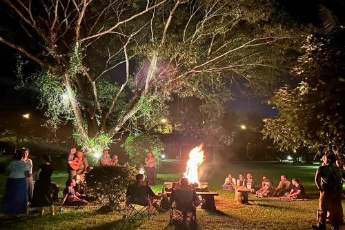a group of people sitting around a fire in a park at Papai Country Lodge SHA in Ban Mae Pong