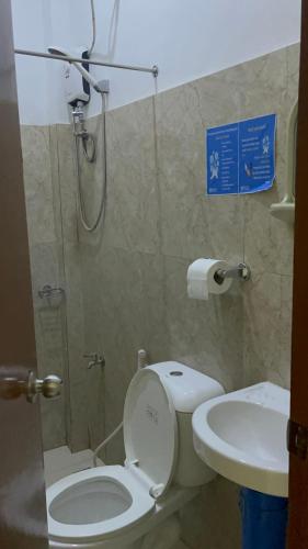 a bathroom with a toilet and a sink at Love Vega Hometel in El Nido