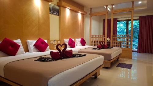 a hotel room with two beds with red pillows at Lanta Summer House 1 in Ko Lanta