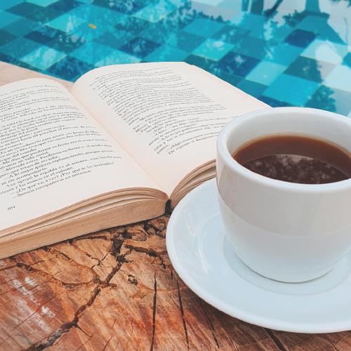 a book and a cup of coffee on a table at Umbral Hotel Boutique in Villavicencio