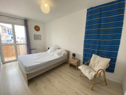 une chambre avec un lit et une chaise dedans dans l'établissement La Teste Centre 2 couchages avec balcon, à La Teste-de-Buch
