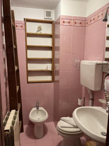 a pink bathroom with a toilet and a sink at Hotel Ristorante Il Principe in Claviere