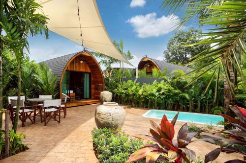 an outdoor patio with a table and chairs and a house at Tropical Chalet-Style 2BR Villa with Pool Pasak Paradise 2, Bangtao in Laguna Phuket