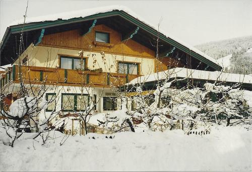 ein schneebedecktes Haus vor der Tür in der Unterkunft Pension Wieser "Baschtlmai" in Altenmarkt im Pongau
