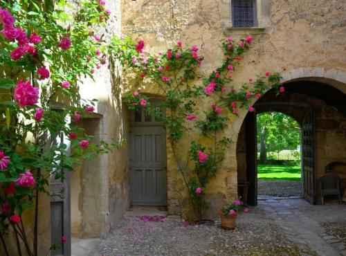 an entrance to a building with pink flowers at Château d'Esparron in Esparron-de-Verdon